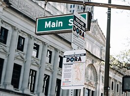 A sign at Main Street and Calhoun Street reminds people of the rules within the new Downtown DORA (Designated Outdoor Refreshment Area).