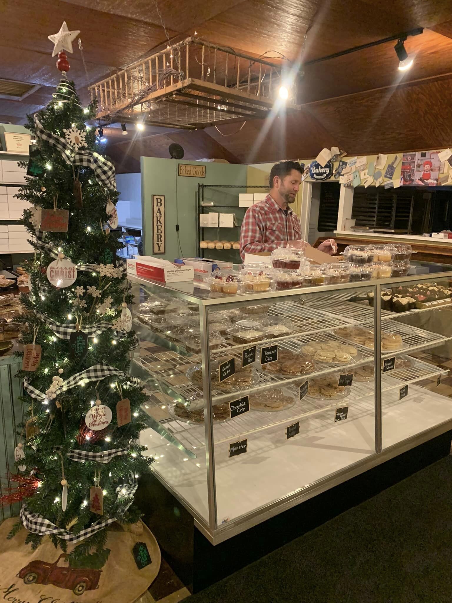 David Jimenez, owner of Nordmann's Nook, pulls a baked good from the display case for a customer.