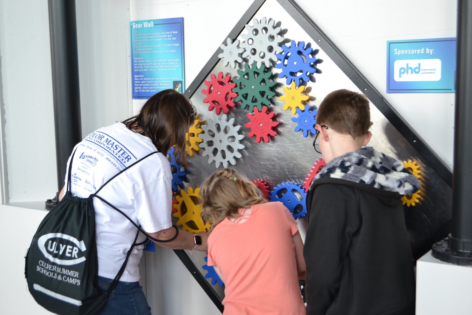 Visitors explore the Gear Wall at Science Central.