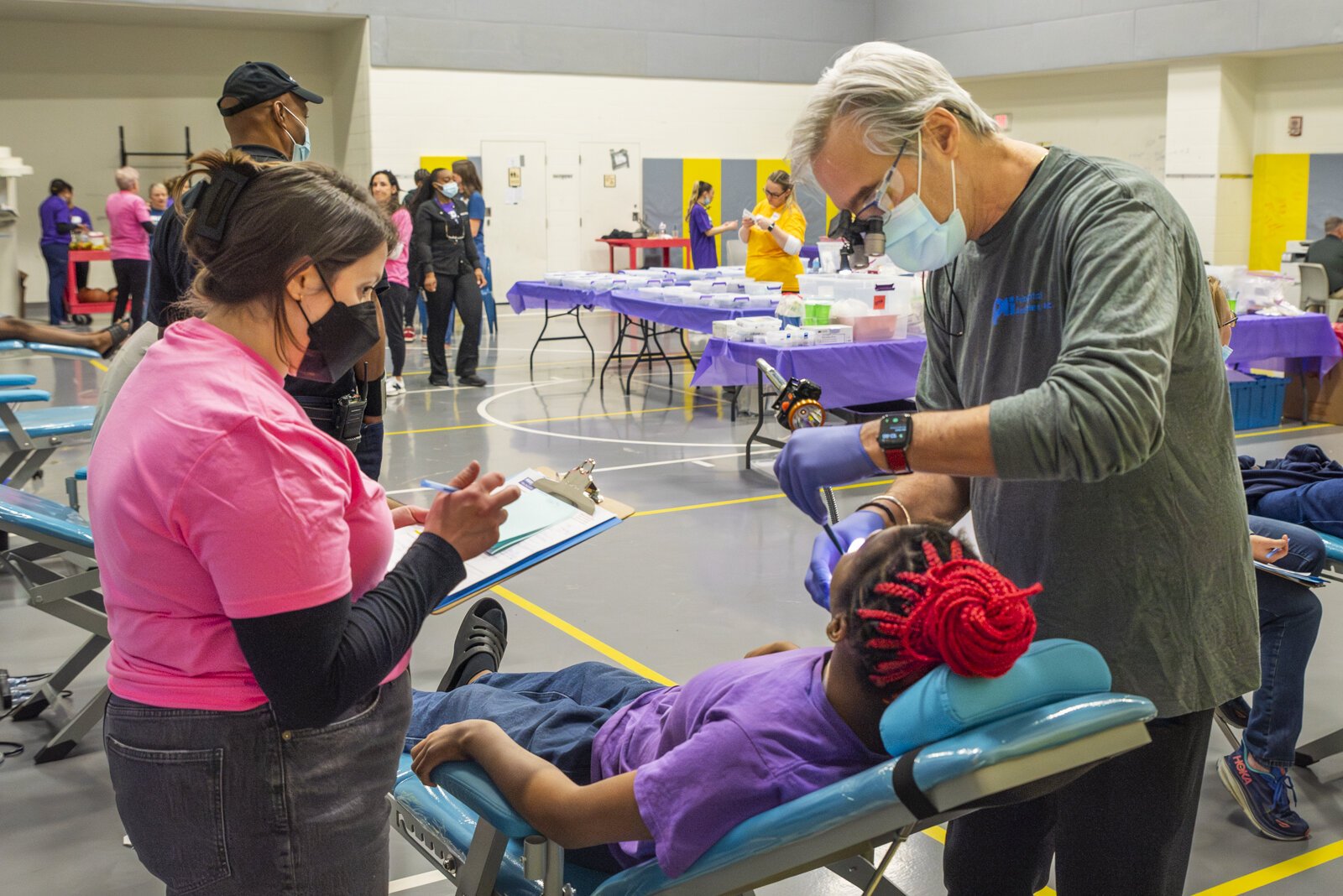 Dr. Roger Hess (right), the Medwish Medworks Chair of Dental Services, works on a patient at the dental clinic.