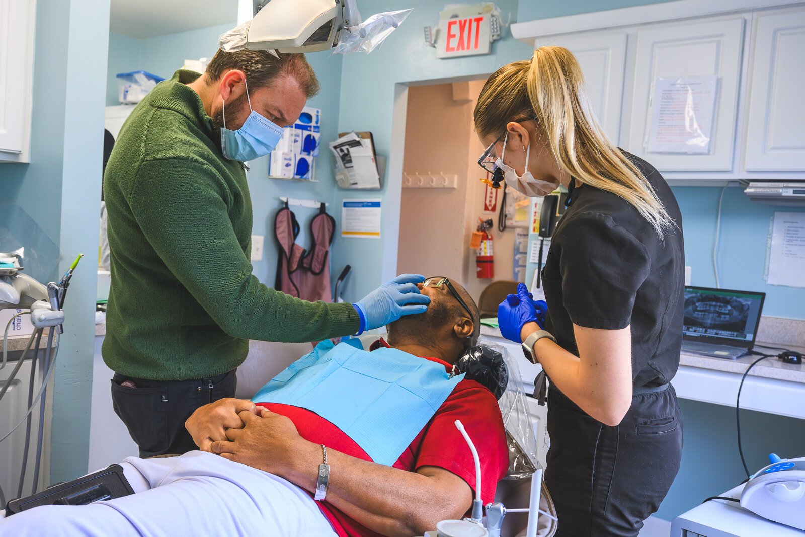 Dr. Ken Marriott, patient Thomas Jones, and dental hygienist Sarah Cawthon at the VINA Community Dental Clinic in Brighton.