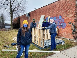 Becky Gonzalez, Bo Gonzalez, Brett Bloom, and Manuel Gonzalez build the Fair Fridge community pantry next to Bravas's new location.