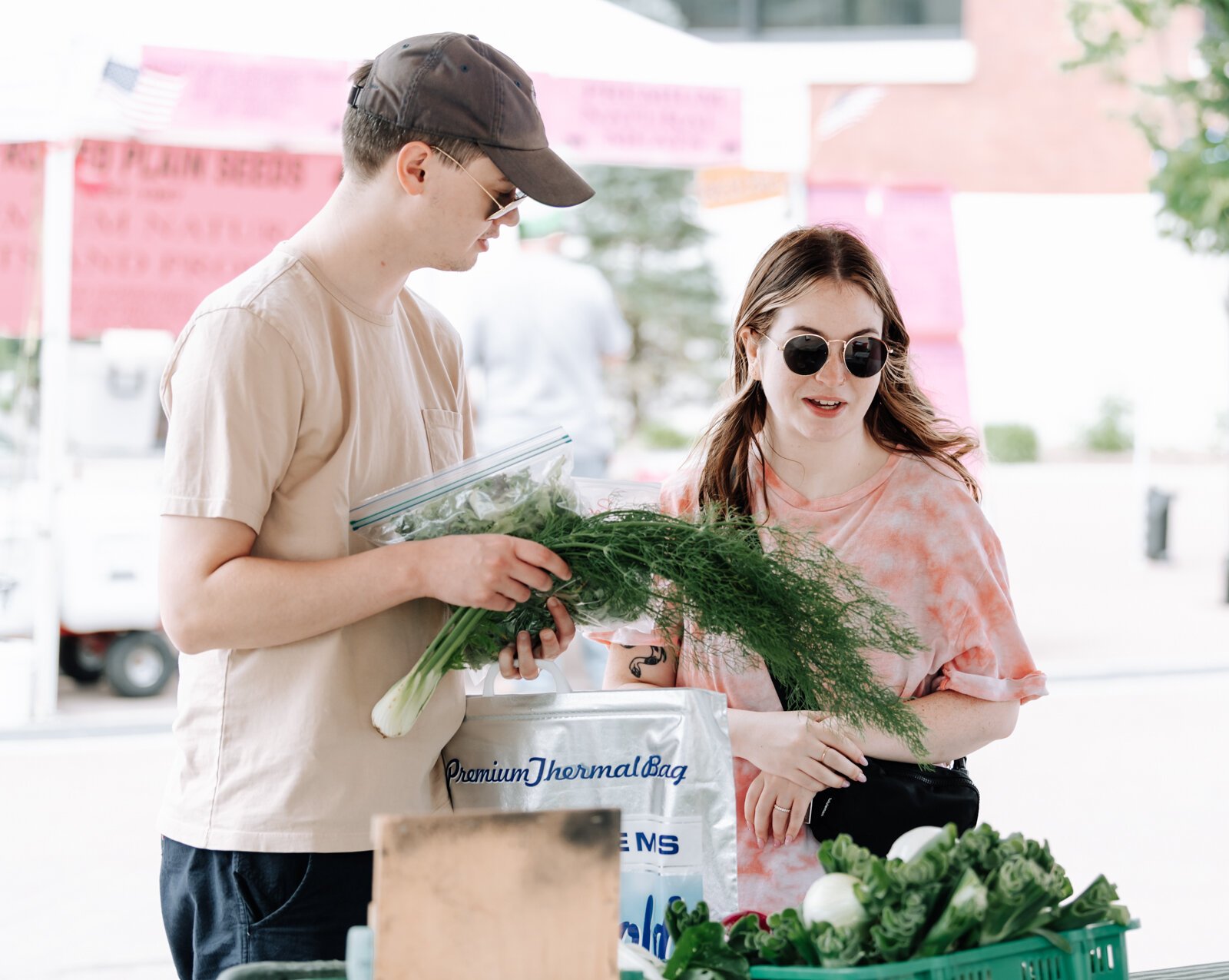 Nathan Skinner, left, and Megan Waid get checked out at the Berry Hill Farm booth during the Fort Wayne's Farmers Market.