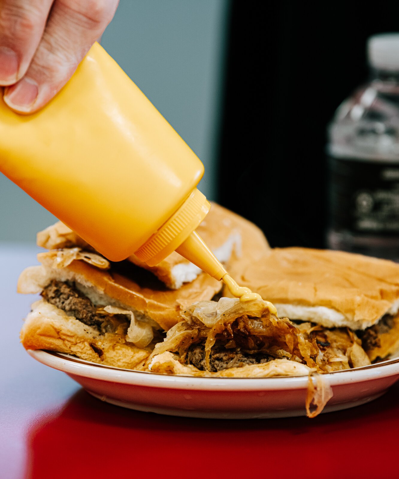 A customer puts mustard on a hamburger at Powers.