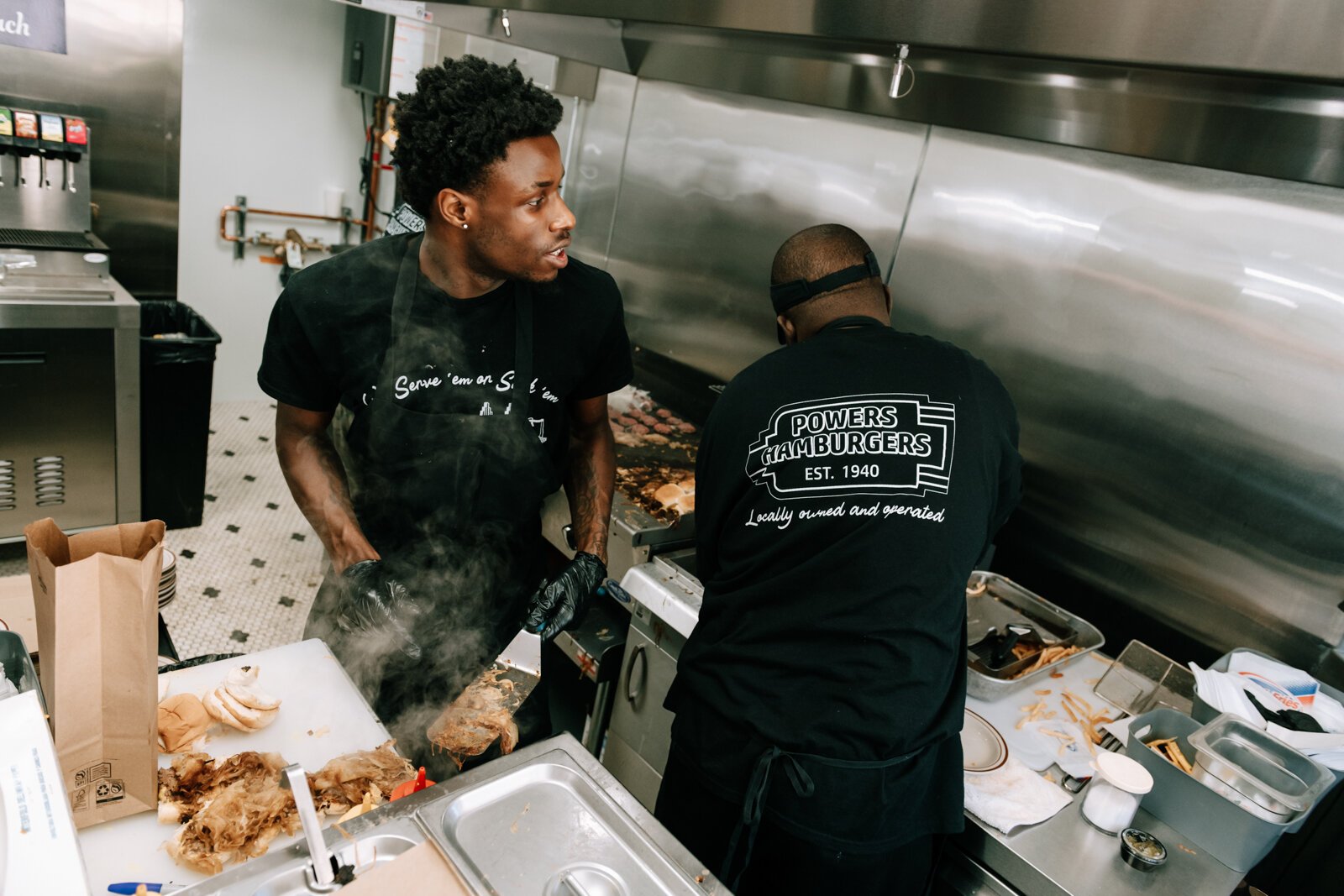 DeJour Hall, left, and Jovone Wright work to get orders out at Powers Hamburgers.