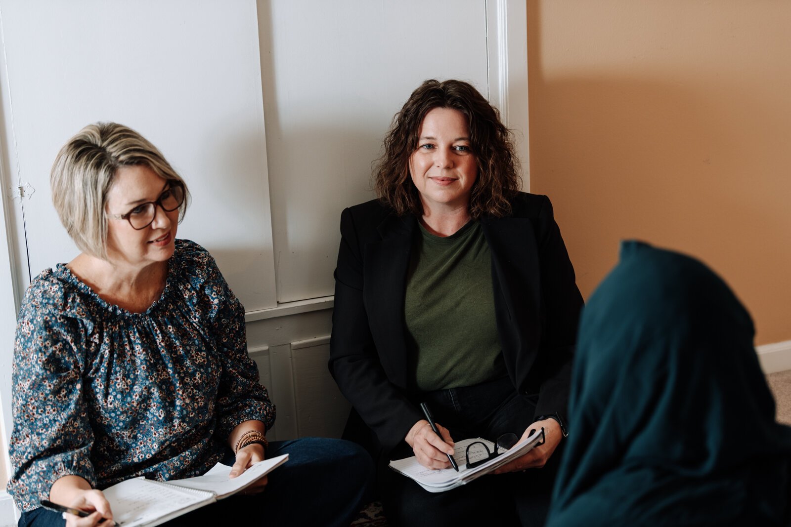 Heather Morris, director of outreach and operations, left, and Valisha Reber, medical and social services liaison demonstrate what a client in-home meeting would look like at the International House office in Fort Wayne.