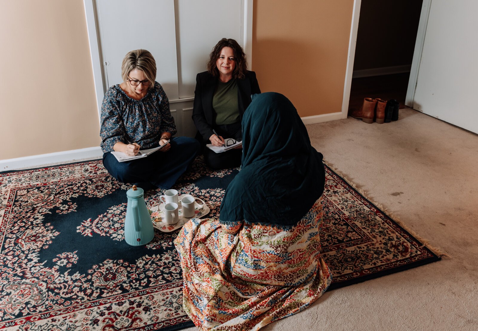 Heather Morris, director of outreach and operations, left, and Valisha Reber, medical and social services liaison demonstrate what a client in-home meeting would look like at the International House office in Fort Wayne.