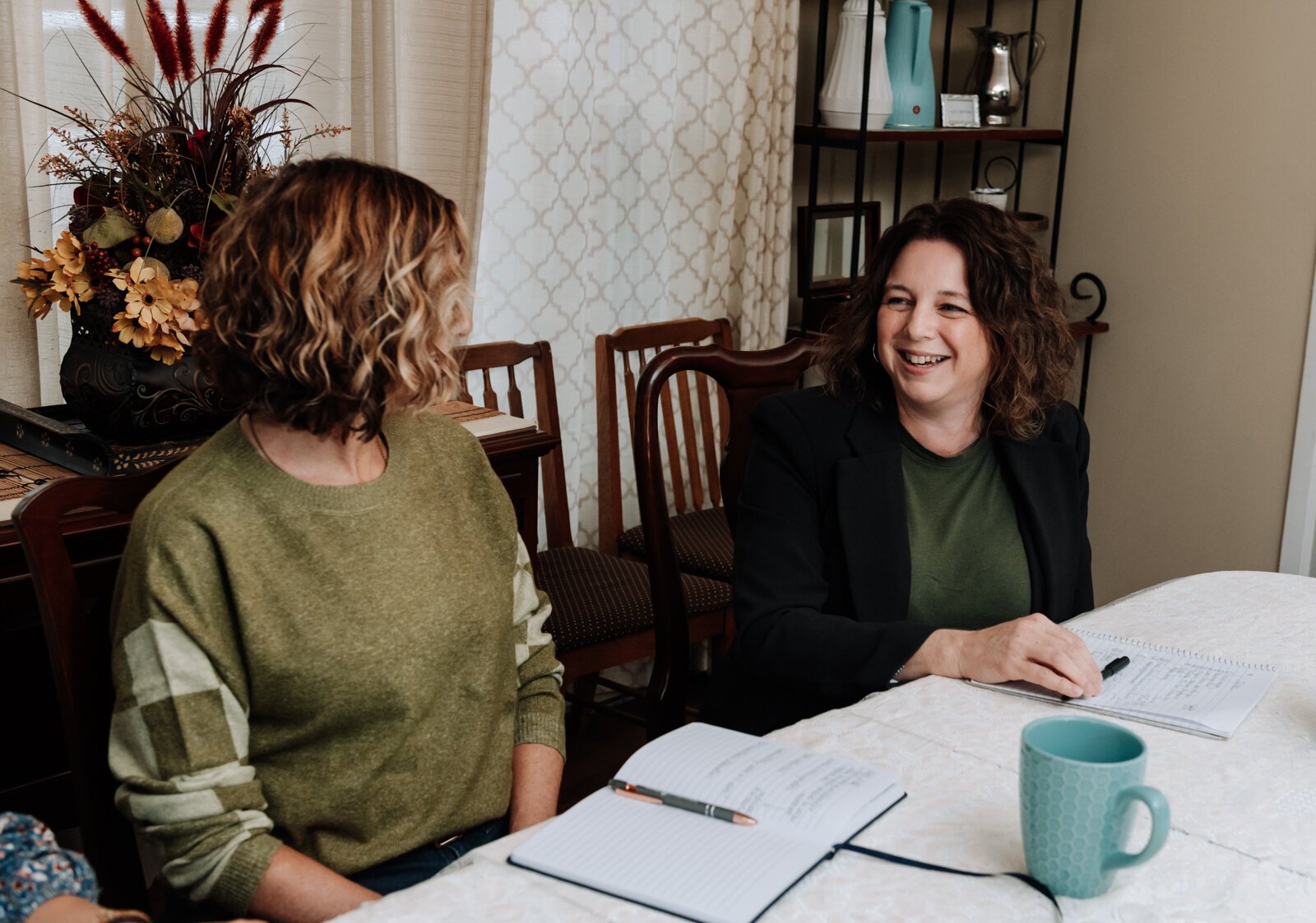 Valisha Reber, medical and social services liaison, right talks with Ann Heign, executive director, during a staff meeting at the International House office.