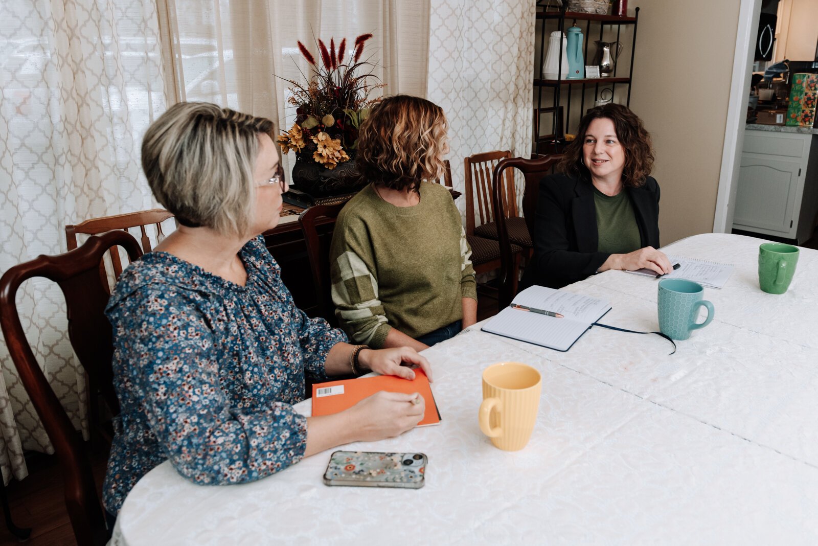 From right: Valisha Reber, medical and social services liaison, right talks with Ann Heign, executive director, and Heather Morris, director of outreach and operations, during a staff meeting at the International House office.