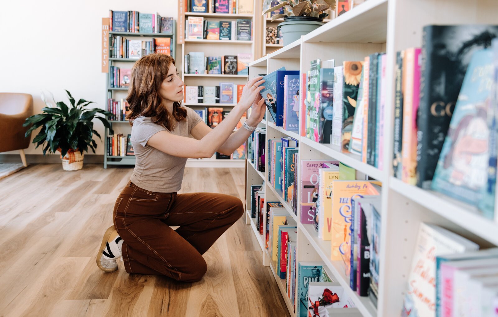 Liz Kelpin arranges books on a shelf at her bookstore, Sunbound Books.