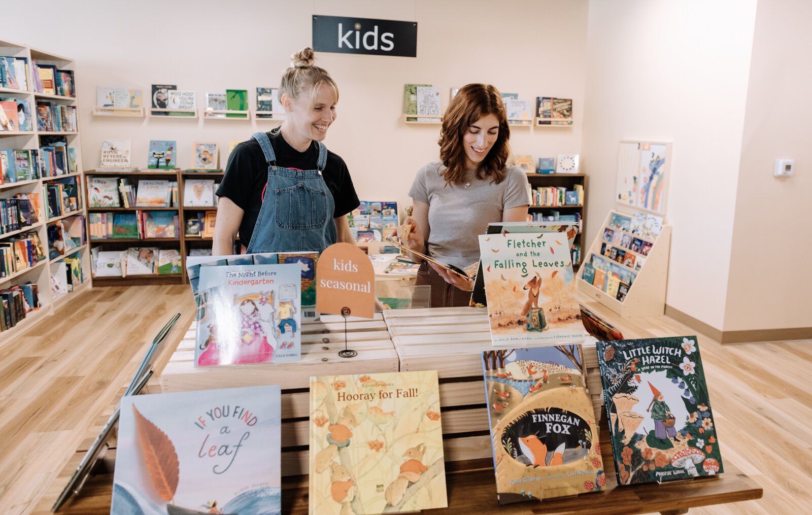 Owner Liz Kelpin and Employee Grace Allison work on a display at Sunbound Books.