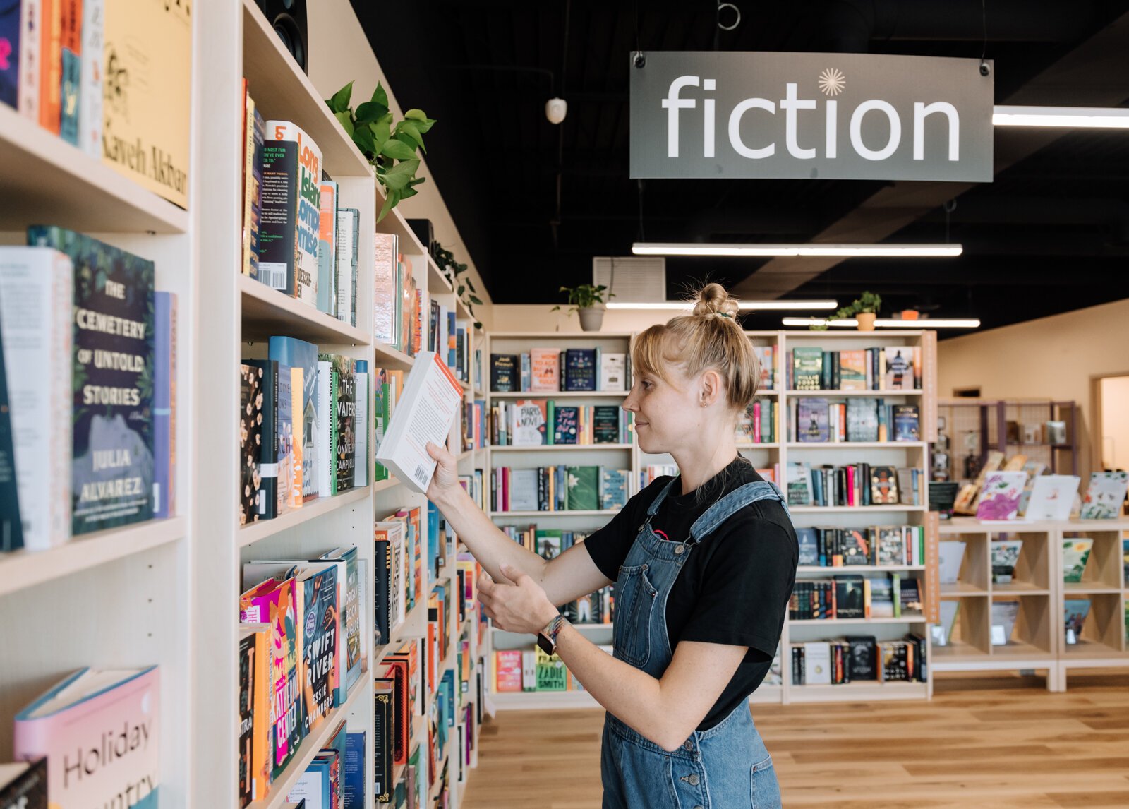 Grace Allison stocking books at Sunbound Books.