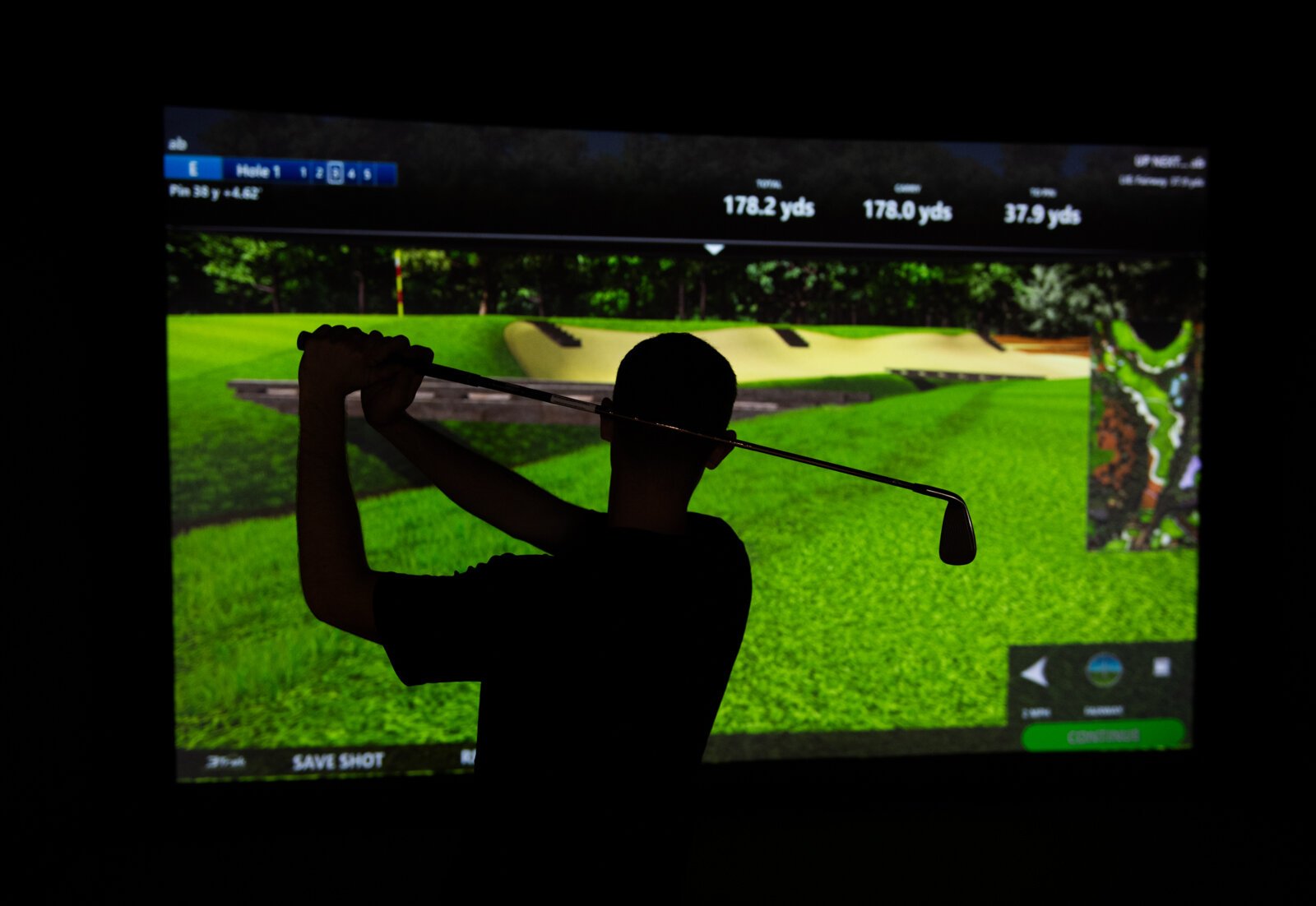 Assistant Pro Wyatt Johnson tests out a golf simulation bay at Urban Golf on the second floor at The Fairfield.