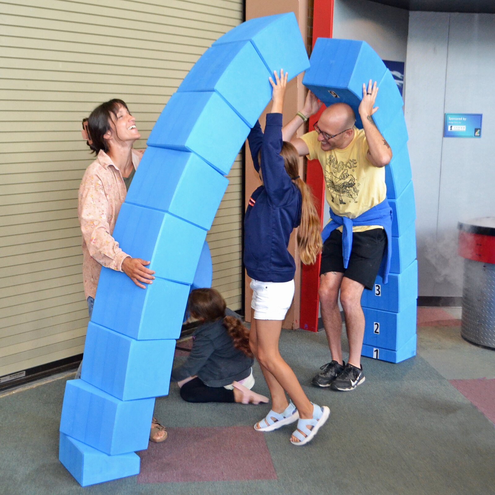 Visitors attempt to build an arch.